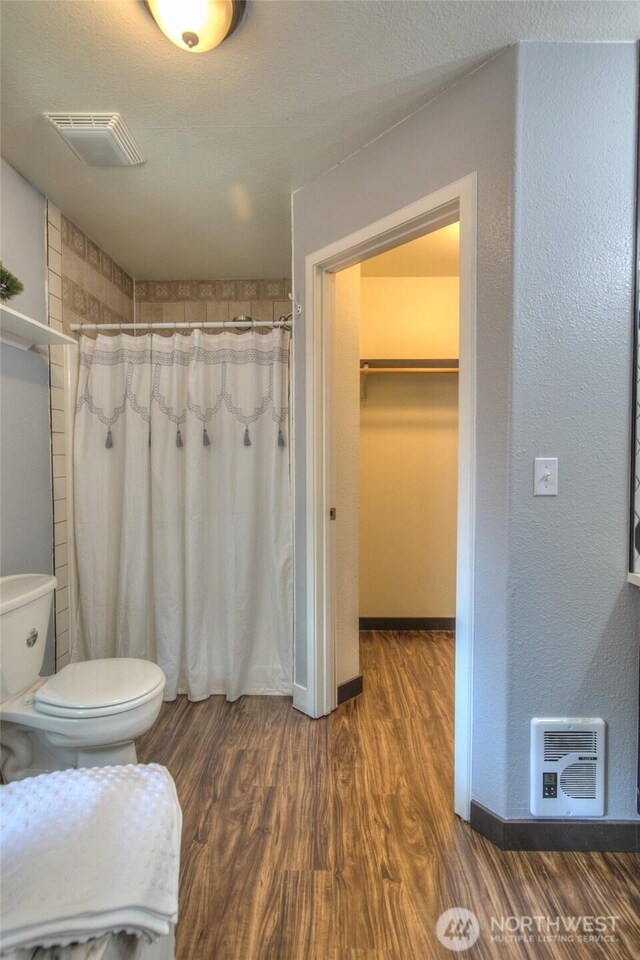 872 Albion Ave SE, Ocean Shores, WA 98569 - full bath featuring toilet, wood finished floors, a shower with shower curtain, heating unit, and a walk in closet