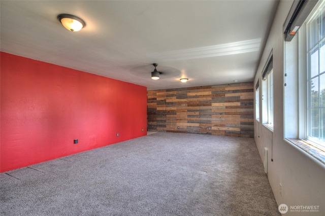 872 Albion Ave SE, Ocean Shores, WA 98569 - spare room featuring wood walls, an accent wall, a ceiling fan, and carpet floors