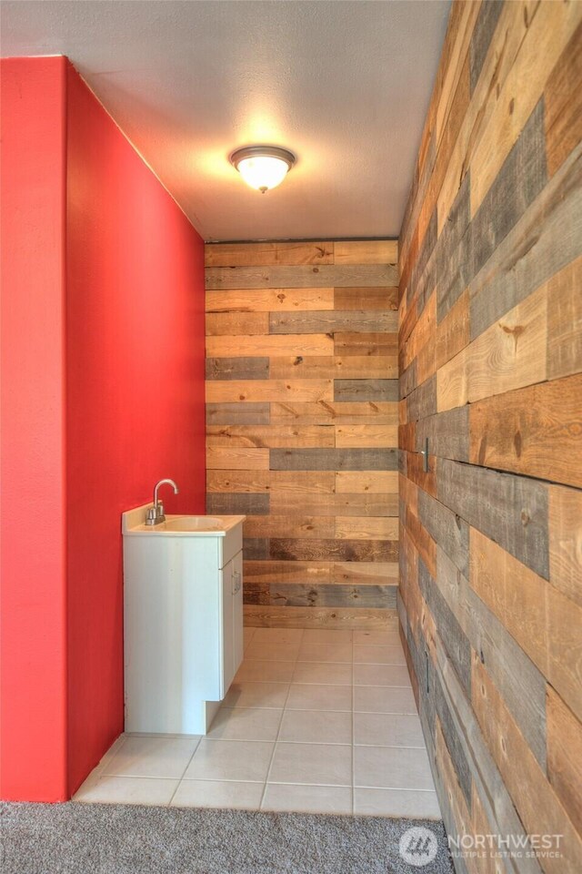 872 Albion Ave SE, Ocean Shores, WA 98569 - hall featuring wood walls, light tile patterned floors, and a textured ceiling
