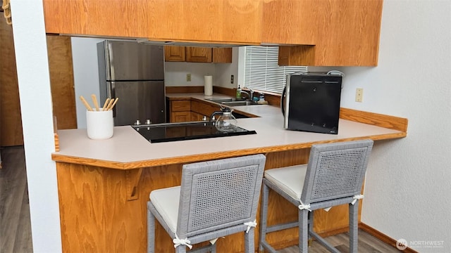 1249 E Ocean Shores Blvd SW, Ocean Shores, WA 98569 - kitchen featuring freestanding refrigerator, brown cabinets, light countertops, and a peninsula