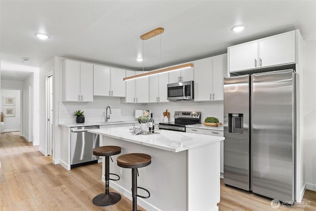 4126 19th Ave SW, Seattle, WA 98106 - kitchen featuring stainless steel appliances, a sink, white cabinetry, tasteful backsplash, and recessed lighting