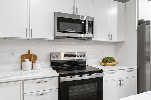 4126 19th Ave SW, Seattle, WA 98106 - kitchen with stainless steel appliances, white cabinets, and decorative backsplash