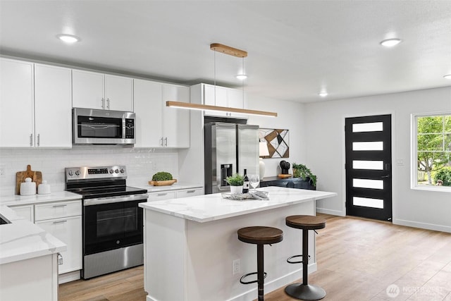 4126 19th Ave SW, Seattle, WA 98106 - kitchen featuring appliances with stainless steel finishes, tasteful backsplash, light wood finished floors, white cabinets, and recessed lighting