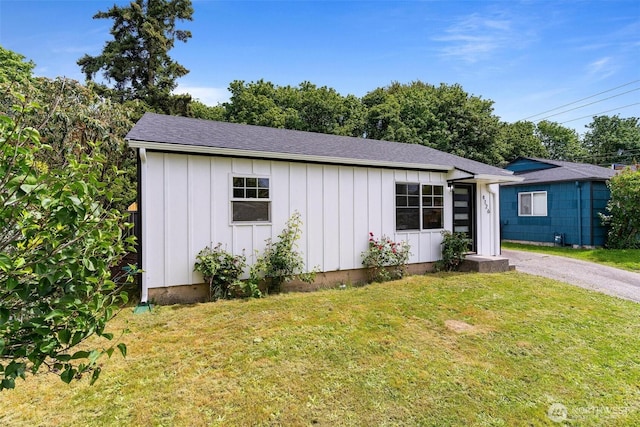 4126 19th Ave SW, Seattle, WA 98106 - view of front of house featuring board and batten siding, a front yard, and roof with shingles