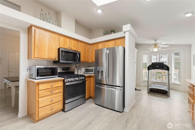 6124 91st St E, Puyallup, WA 98371 - kitchen with stainless steel appliances, light wood finished floors, ceiling fan, light countertops, and recessed lighting