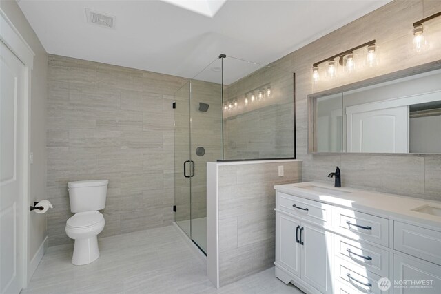 5020 Gold Ridge Ln SW, Olympia, WA 98512 - bathroom featuring tile walls, a shower stall, double vanity, and toilet