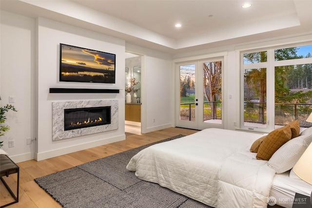 21412 NE 16th St, Sammamish, WA 98074 - bedroom with access to outside, wood finished floors, a tray ceiling, french doors, and recessed lighting