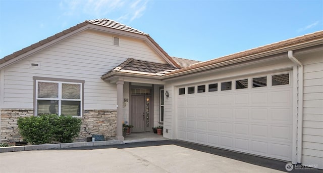 1494 Eastmont Ave Unit 58, East Wenatchee, WA 98802 - view of front of property with a garage, stone siding, and driveway