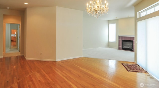 1494 Eastmont Ave Unit 58, East Wenatchee, WA 98802 - unfurnished living room with wood finished floors, a tile fireplace, a chandelier, and recessed lighting