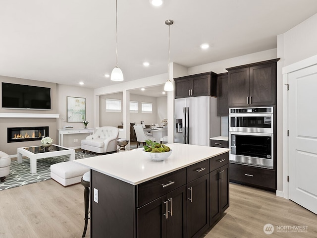 768 SE 11th Pl Lot 05, North Bend, WA 98045 - kitchen with appliances with stainless steel finishes, open floor plan, light countertops, light wood-style flooring, and a center island