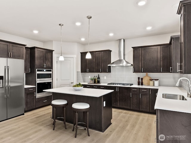 768 SE 11th Pl Lot 05, North Bend, WA 98045 - kitchen featuring appliances with stainless steel finishes, a sink, wall chimney exhaust hood, a center island, and dark brown cabinets