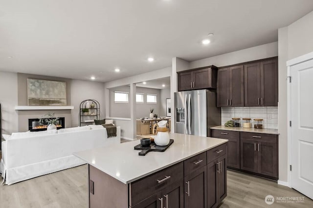 768 SE 11th Pl Lot 05, North Bend, WA 98045 - kitchen with stainless steel refrigerator with ice dispenser, light wood-style floors, light countertops, dark brown cabinets, and tasteful backsplash