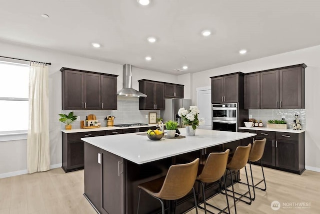 716 SE 11th Pl Unit 7, North Bend, WA 98045 - kitchen featuring wall chimney range hood, stainless steel appliances, light countertops, backsplash, and recessed lighting