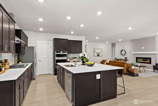 716 SE 11th Pl Unit 7, North Bend, WA 98045 - kitchen featuring appliances with stainless steel finishes, a sink, open floor plan, decorative backsplash, and recessed lighting