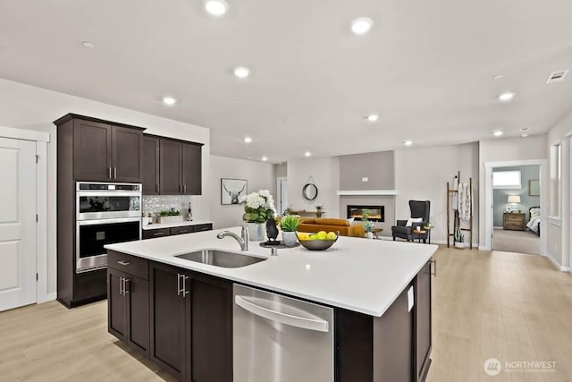 716 SE 11th Pl Unit 7, North Bend, WA 98045 - kitchen with stainless steel appliances, a sink, a center island with sink, light countertops, and recessed lighting
