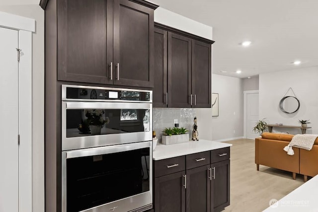 716 SE 11th Pl Unit 7, North Bend, WA 98045 - kitchen featuring double oven, tasteful backsplash, light wood-style flooring, recessed lighting, and dark brown cabinets