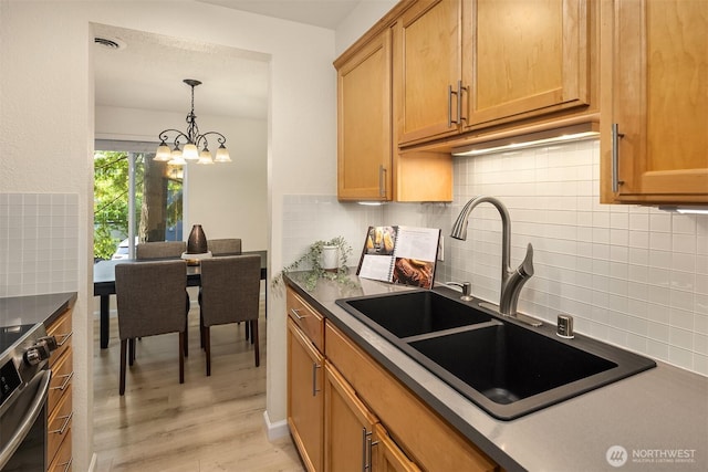 12223 NE Bel-Red Rd Unit D105, Bellevue, WA 98005 - kitchen with a sink, backsplash, stainless steel stove, and a chandelier
