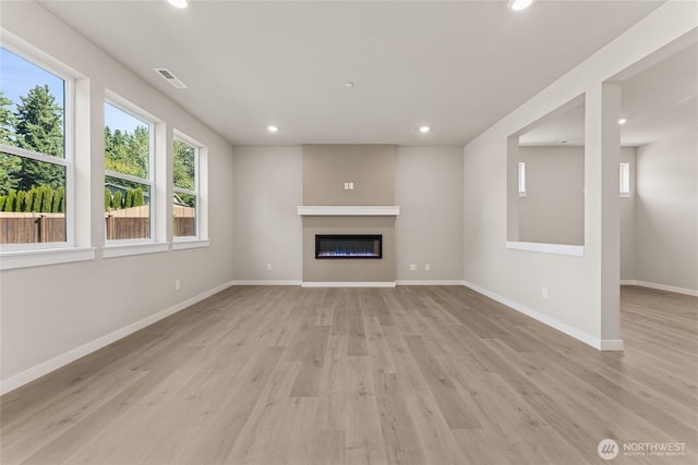 3822 98th Avenue Ct E Unit 9, Edgewood, WA 98371 - unfurnished living room with plenty of natural light, recessed lighting, light wood-style floors, and a glass covered fireplace