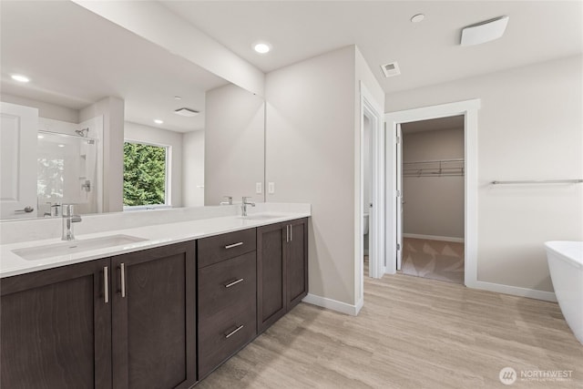 3822 98th Avenue Ct E Unit 9, Edgewood, WA 98371 - full bathroom with a shower stall, double vanity, a freestanding tub, wood finished floors, and a walk in closet