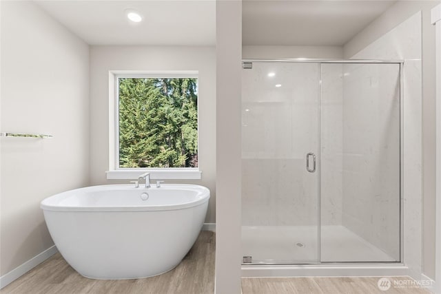 3822 98th Avenue Ct E Unit 9, Edgewood, WA 98371 - bathroom featuring wood finished floors, a soaking tub, and a shower stall
