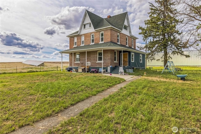 8495 Williams Rd E, Wilbur, WA 99185 - rear view of house with brick siding, a shingled roof, entry steps, a chimney, and a patio