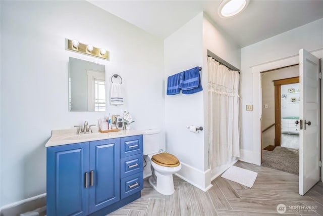 8495 Williams Rd E, Wilbur, WA 99185 - bathroom featuring toilet, vanity, baseboards, and a shower with shower curtain