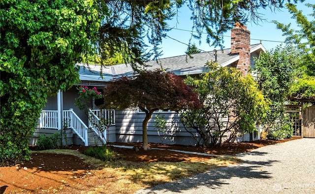 11816 40th Ave S, Tukwila, WA 98168 - view of property hidden behind natural elements featuring a chimney and covered porch