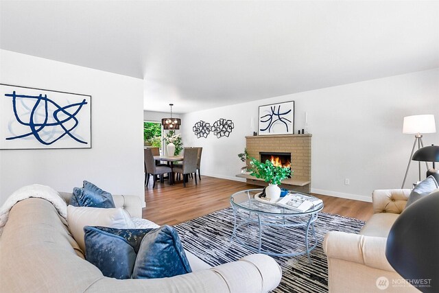 1231 121st Pl SE, Everett, WA 98208 - living room with wood finished floors, a brick fireplace, and baseboards