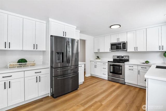 1231 121st Pl SE, Everett, WA 98208 - kitchen featuring stainless steel appliances, light wood-style flooring, light countertops, and white cabinets