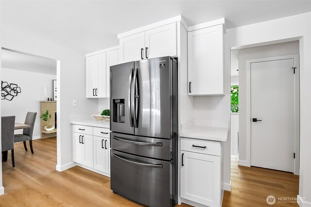 1231 121st Pl SE, Everett, WA 98208 - kitchen featuring stainless steel fridge, light countertops, light wood-style floors, and white cabinetry