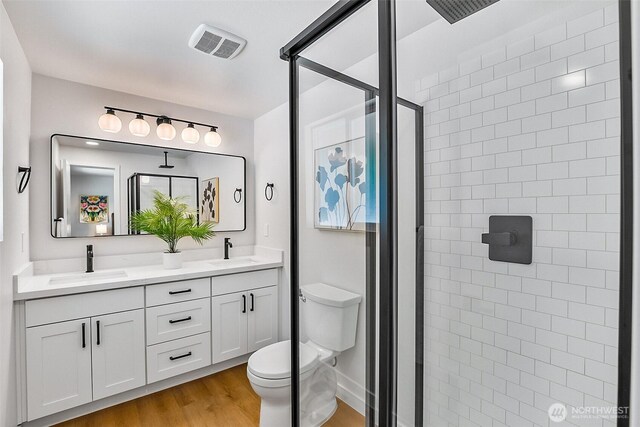 1231 121st Pl SE, Everett, WA 98208 - bathroom with a shower stall, wood finished floors, toilet, and double vanity