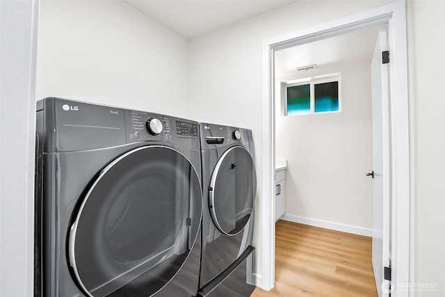 1231 121st Pl SE, Everett, WA 98208 - laundry room featuring washing machine and dryer, baseboards, and light wood-type flooring