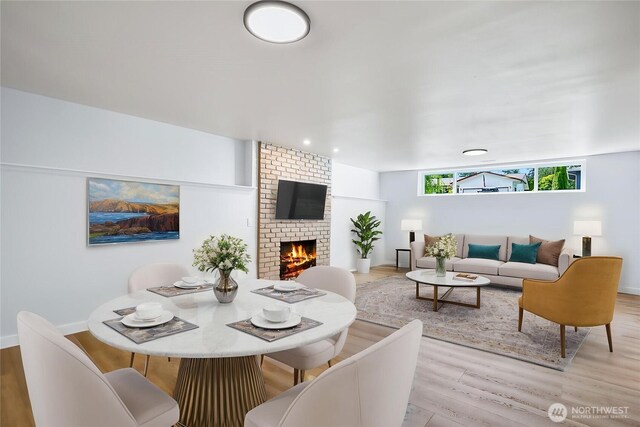 1231 121st Pl SE, Everett, WA 98208 - dining space featuring wood finished floors, a brick fireplace, and baseboards