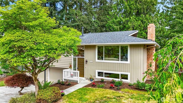 1231 121st Pl SE, Everett, WA 98208 - split foyer home featuring a chimney, a shingled roof, and a front lawn