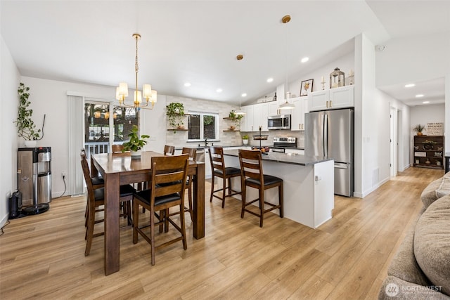 21710 104th Ave E, Graham, WA 98338 - dining space featuring light wood-style floors, a chandelier, lofted ceiling, healthy amount of natural light, and recessed lighting