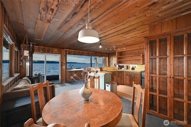 8204 Naketa Beach Walk, Mukilteo, WA 98275 - dining space with wooden ceiling, wood walls, a water view, carpet flooring, and rail lighting