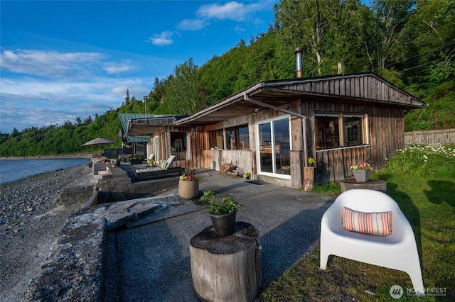 8204 Naketa Beach Walk, Mukilteo, WA 98275 - rear view of house featuring a patio area, a water view, and a wooded view
