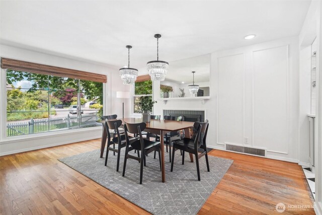 603 NW 52nd St, Seattle, WA 98107 - dining room featuring wood finished floors, a chandelier, recessed lighting, and a fireplace