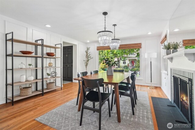 603 NW 52nd St, Seattle, WA 98107 - dining area featuring a fireplace with flush hearth, a chandelier, wood finished floors, and recessed lighting