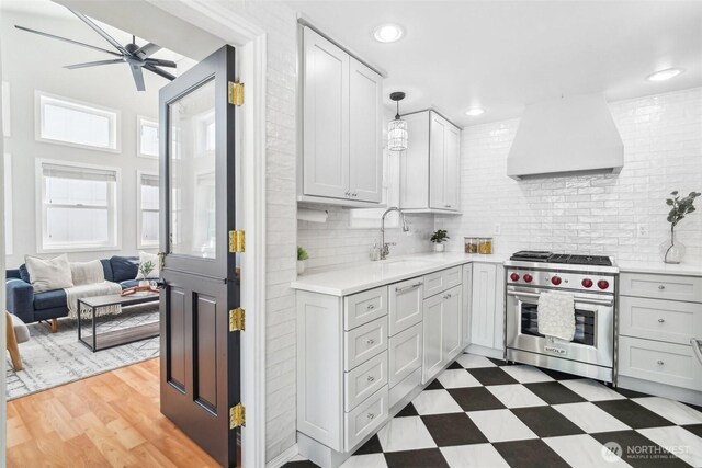 603 NW 52nd St, Seattle, WA 98107 - kitchen with premium stove, custom exhaust hood, ceiling fan, a sink, and light countertops