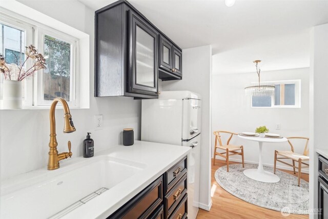 603 NW 52nd St, Seattle, WA 98107 - kitchen with a sink, light countertops, light wood-style floors, and freestanding refrigerator