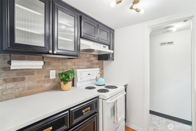 603 NW 52nd St, Seattle, WA 98107 - kitchen featuring electric range, under cabinet range hood, light countertops, glass insert cabinets, and baseboards