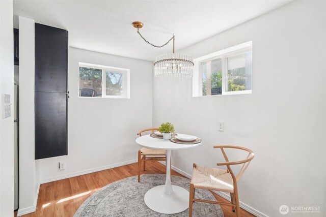 603 NW 52nd St, Seattle, WA 98107 - dining area featuring a chandelier, wood finished floors, and baseboards