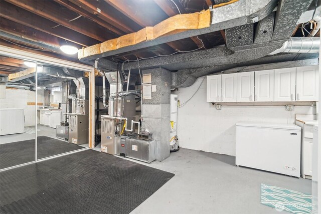 603 NW 52nd St, Seattle, WA 98107 - unfinished basement with white fridge, washer / clothes dryer, water heater, and heating unit