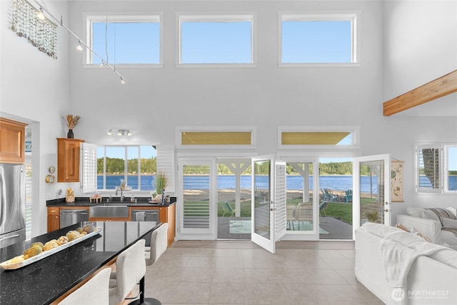 62 E N Bay Rd, Allyn, WA 98524 - kitchen featuring a high ceiling, a sink, appliances with stainless steel finishes, a water view, and light tile patterned flooring