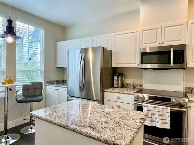 4459 249th Ter SE Unit 8-5, Issaquah, WA 98029 - kitchen featuring stainless steel appliances, white cabinets, light stone countertops, decorative light fixtures, and a center island