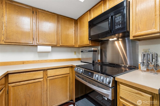 8407 18th Ave W Unit 6-104, Everett, WA 98204 - kitchen featuring stainless steel electric stove, black microwave, light countertops, and brown cabinets