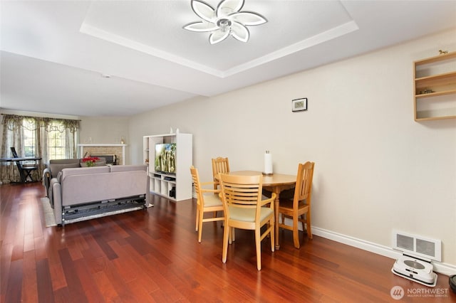 8407 18th Ave W Unit 6-104, Everett, WA 98204 - dining room with a ceiling fan, wood finished floors, a tray ceiling, baseboards, and a fireplace
