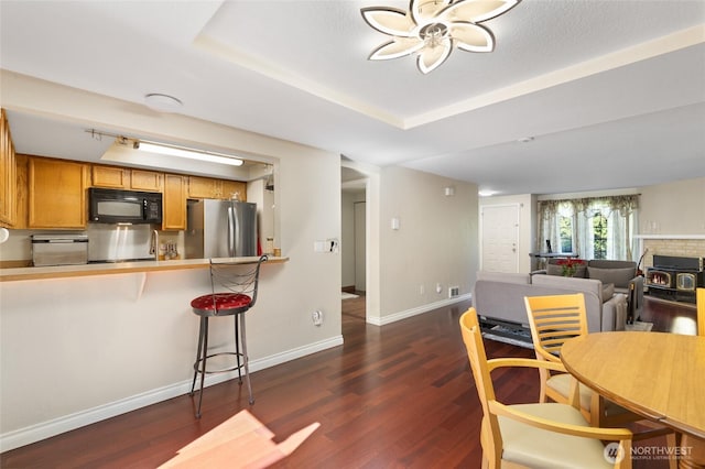 8407 18th Ave W Unit 6-104, Everett, WA 98204 - kitchen with black microwave, freestanding refrigerator, dark wood-style flooring, and baseboards