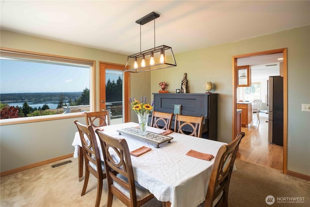 8082 Daniel Pl NW, Silverdale, WA 98383 - dining space with light colored carpet, baseboards, and a chandelier